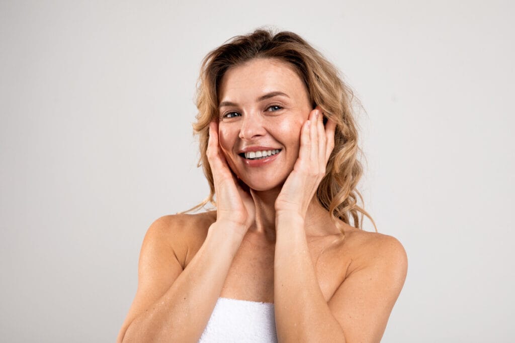 Mature woman touching cheeks and smiling