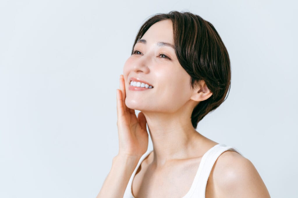 Asian woman touching face and smiling